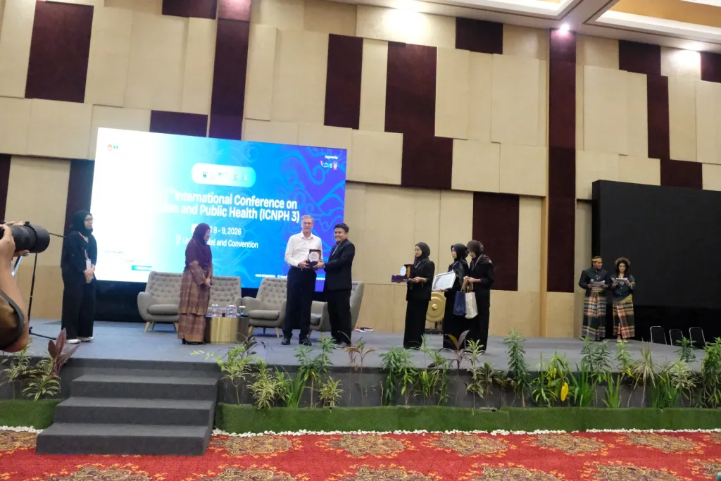 Membangun Sinergi Gizi Global. Momen penyerahan penghargaan kepada salah satu pembicara ahli dalam ajang The 3rd International Conference on Nutrition and Public Health (ICNPH 3) sebagai simbol kolaborasi lintas sektor dalam merumuskan solusi berbasis bukti bagi kesehatan dunia pada 8 April 2026 di Makassar. (Foto: Dokumen Pribadi).